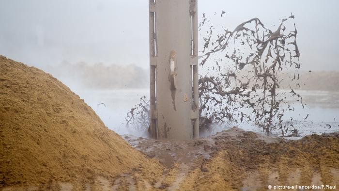 Machinery compressing the group of a future lake (picture-alliance/dpa/P.Pleul)