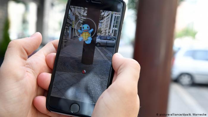 Deutschland Mann spielt Pokemon Go auf Smartphone