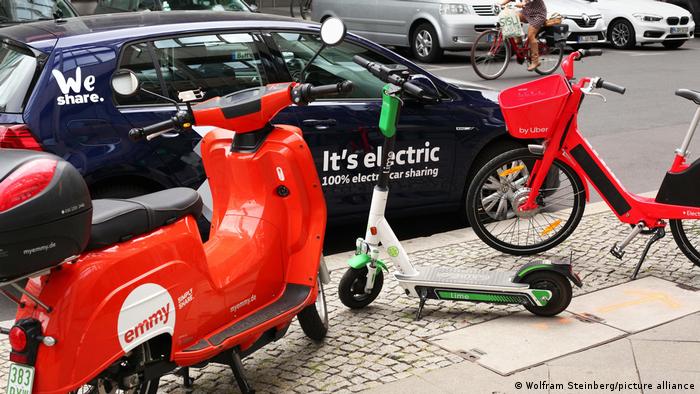 E-Auto, E-Bike und E-Roller am Straßenrand von Berlin zum Ausleihen. 