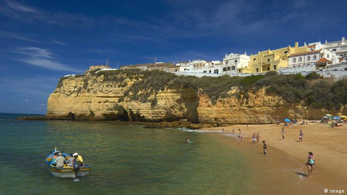 Ein Boot und Badenden am Algarve-Strand in Portugal  Ein Boot und Badenden am Algarve-Strand in Portugal