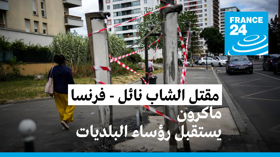 أحد المارة أمام محطة حافلات محترقة بعد احتجاجات في كولومب، بالقرب من باريس، في 1 يوليو 2023.