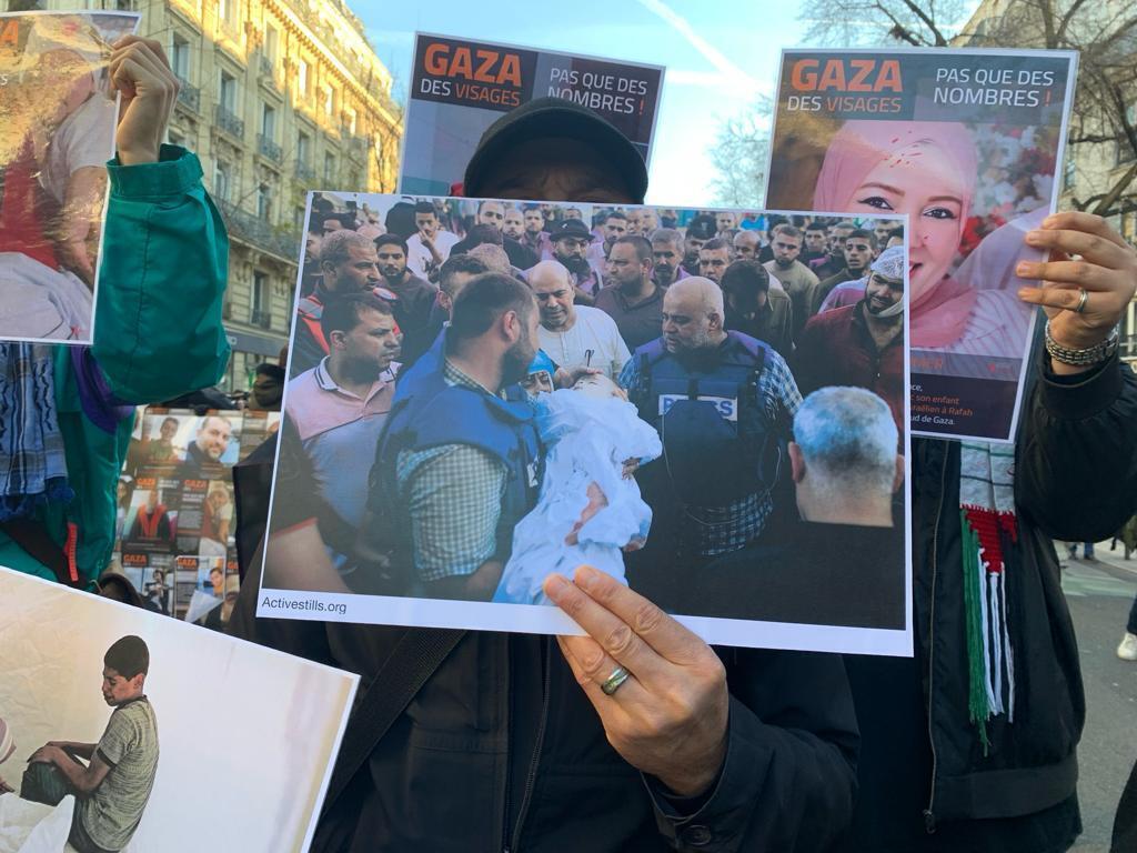 أحد المشاركين في مظاهرة مؤيدة للفلسطينيين في باريس يوم الأحد 17 ديسمبر/كانون الأول 2023، يرفع صورة مراسل الجزيرة في غزة وائل الدحدوح، خلال جنازة طفلته، 26 أكتوبر/تشرين الأول 2023.